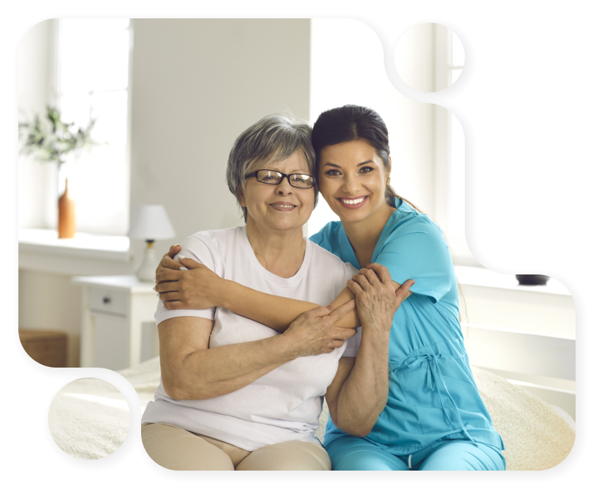 elderly woman and caretaker hug each other