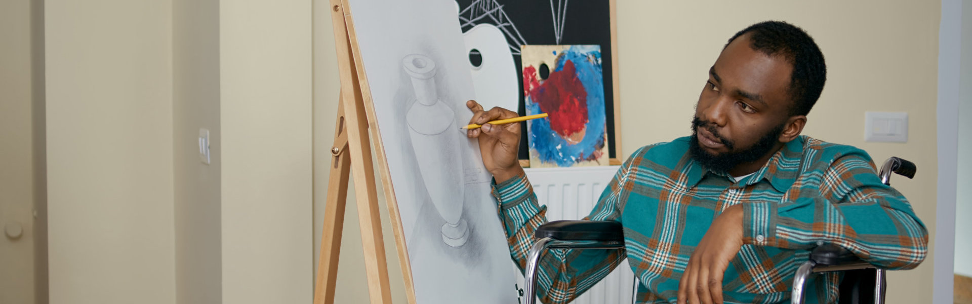 man using pencil to draw on canvas